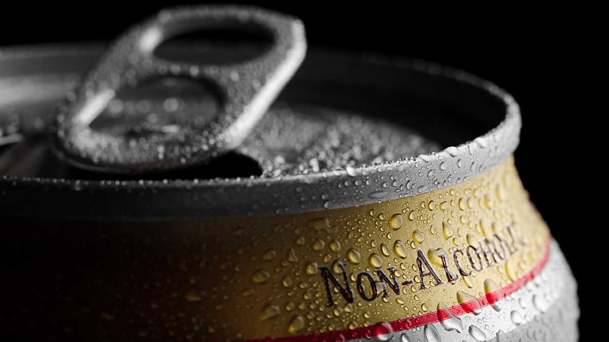 A can of non-alcoholic beer covered in condensation.