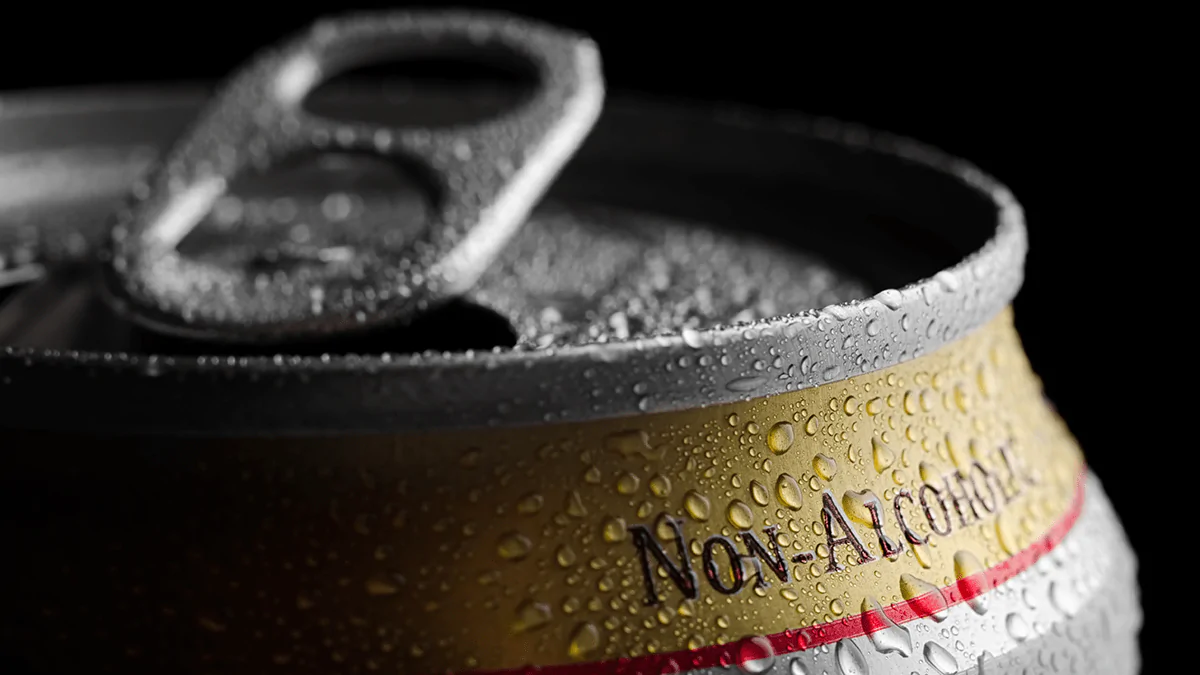 A can of non-alcoholic beer covered in condensation.